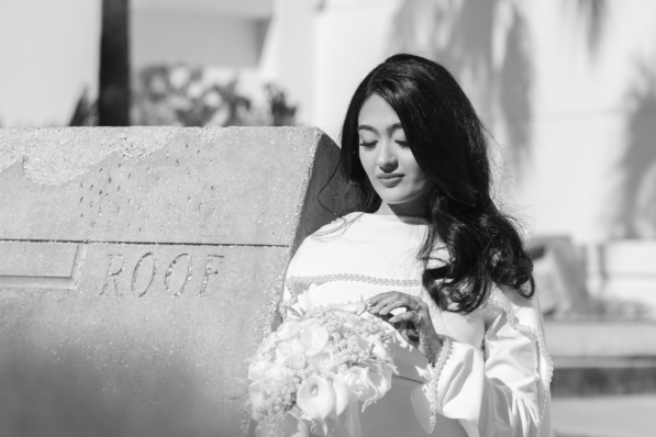 A newly married couple smiling and walking down the steps of the Hillsborough County Courthouse after their downtown Tampa wedding ceremony by imkashi Photography