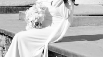 A newly married couple smiling and walking down the steps of the Hillsborough County Courthouse after their downtown Tampa wedding ceremony by imkashi Photography