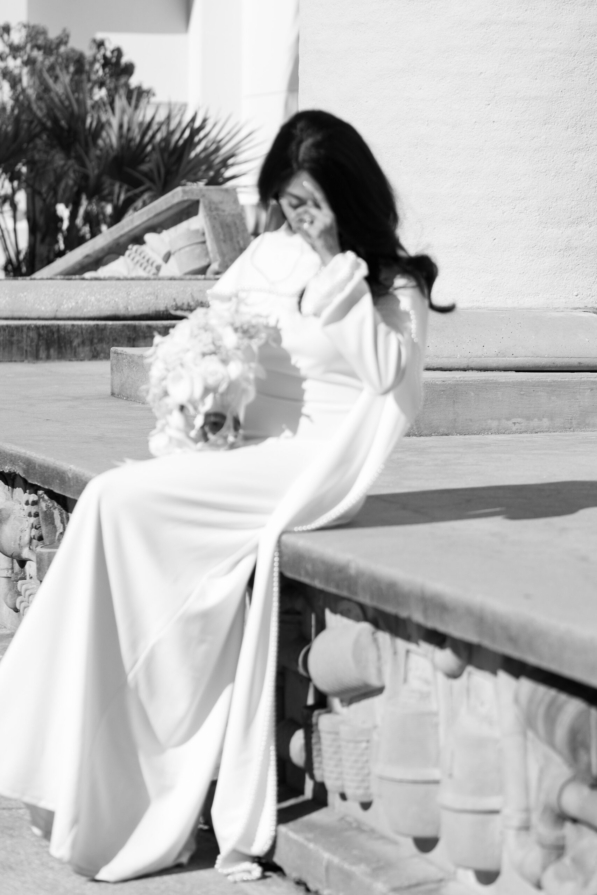 A newly married couple smiling and walking down the steps of the Hillsborough County Courthouse after their downtown Tampa wedding ceremony by imkashi Photography