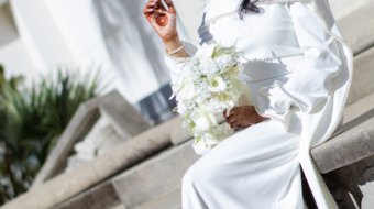 A newly married couple smiling and walking down the steps of the Hillsborough County Courthouse after their downtown Tampa wedding ceremony by imkashi Photography