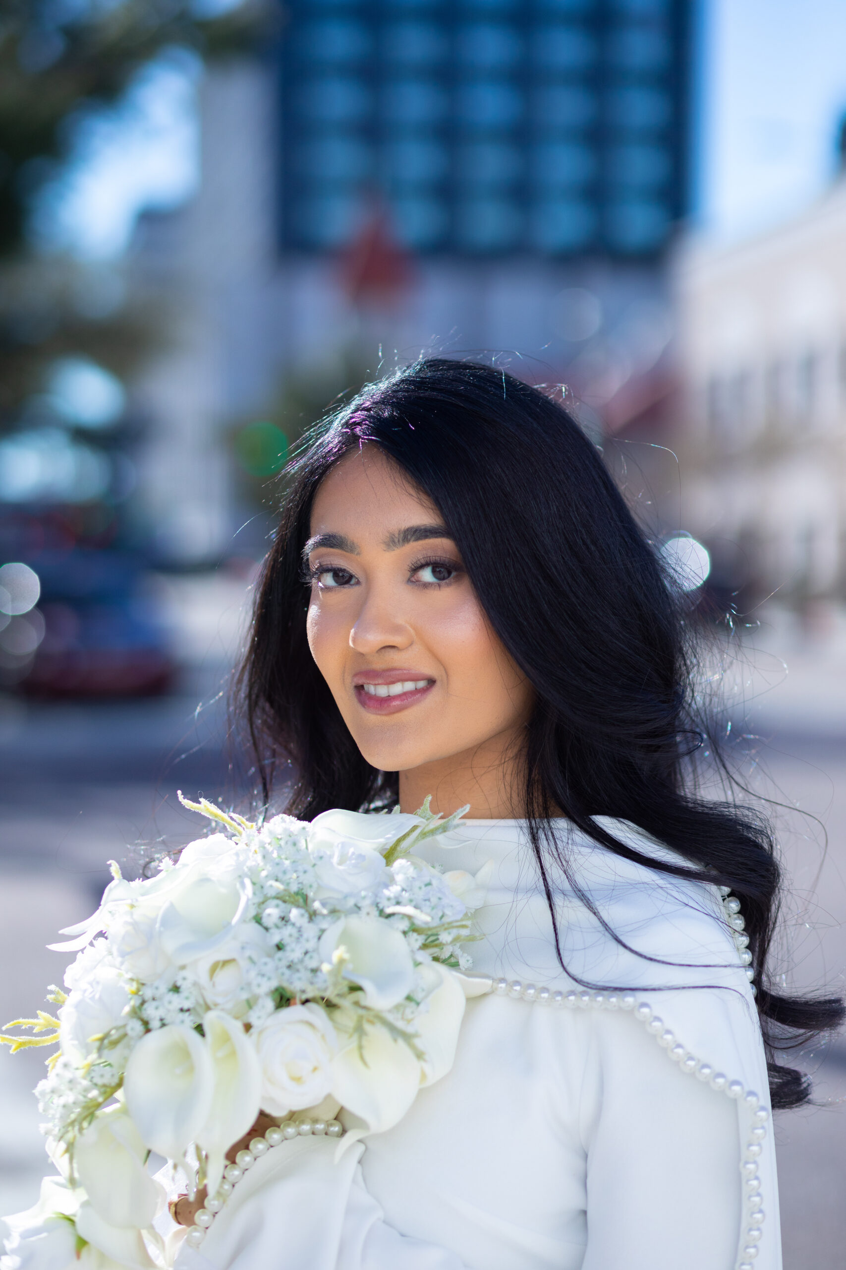 A newly married couple smiling and walking down the steps of the Hillsborough County Courthouse after their downtown Tampa wedding ceremony by imkashi Photography