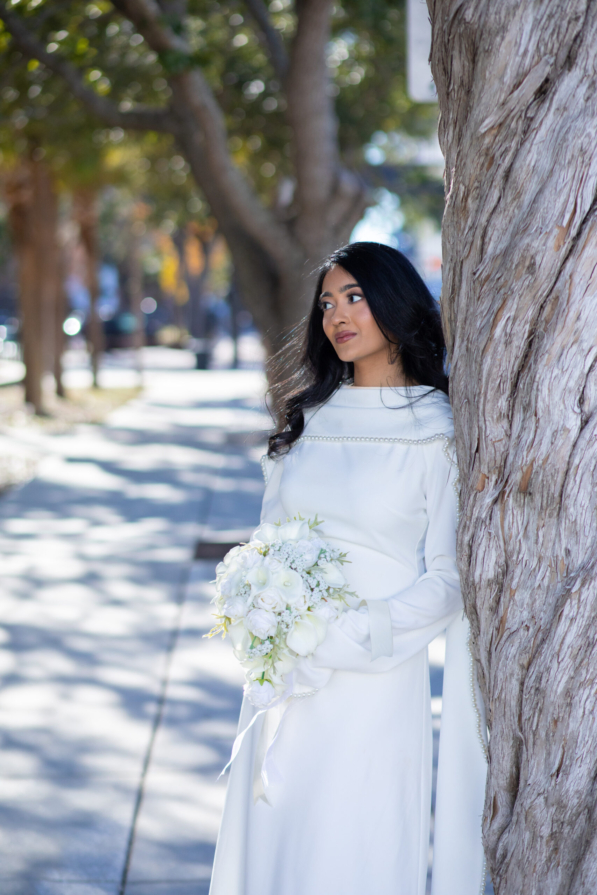 A newly married couple smiling and walking down the steps of the Hillsborough County Courthouse after their downtown Tampa wedding ceremony by imkashi Photography