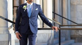 A newly married couple smiling and walking down the steps of the Hillsborough County Courthouse after their downtown Tampa wedding ceremony by imkashi Photography