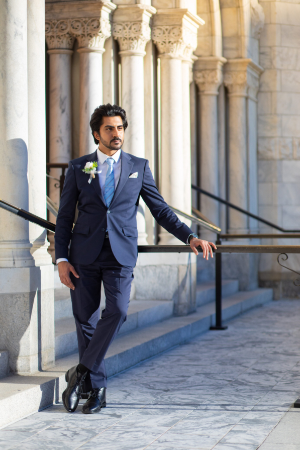 A newly married couple smiling and walking down the steps of the Hillsborough County Courthouse after their downtown Tampa wedding ceremony by imkashi Photography
