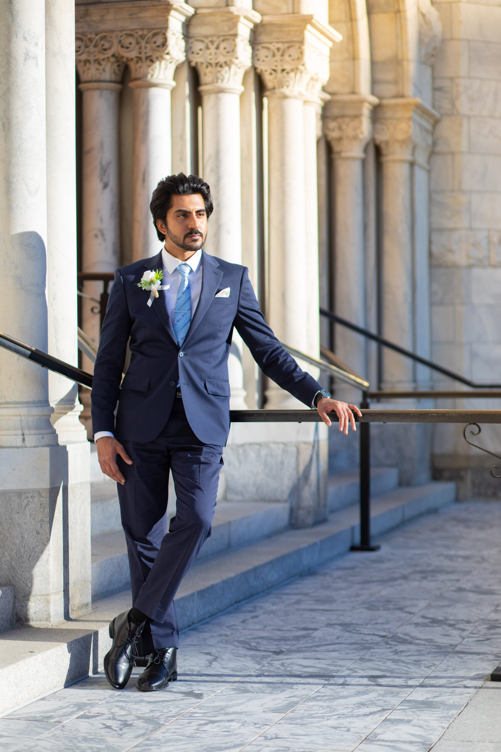 A newly married couple smiling and walking down the steps of the Hillsborough County Courthouse after their downtown Tampa wedding ceremony by imkashi Photography