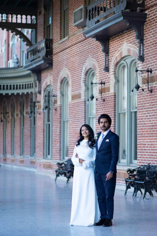 A bride and groom posing for romantic wedding portraits in downtown Tampa near the courthouse squares with city architecture backgrounds by imkashi Photography