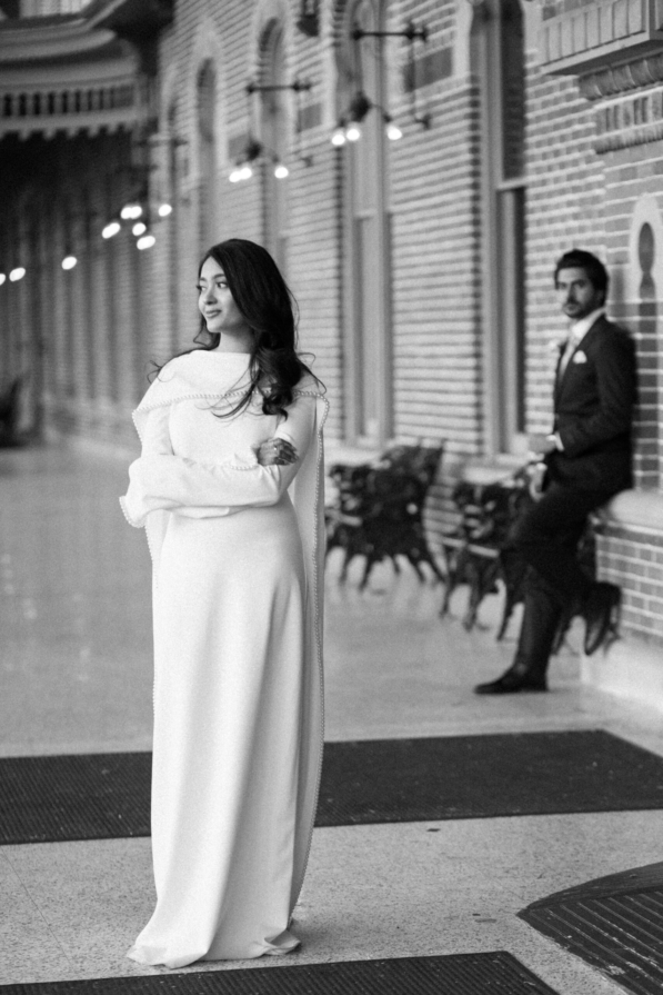 A newly married couple smiling and walking down the steps of the Hillsborough County Courthouse after their downtown Tampa wedding ceremony by imkashi Photography